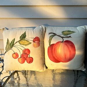 Two throw pillows:cherries and an apple